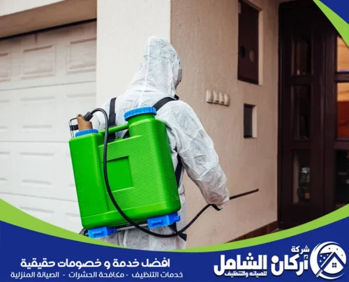 عامل مكافحة حشرات يرتدي ملابس وقائية ويستخدم جهاز رذاذ للحفاظ على المنازل آمنة وصحية. شركة أركان الشامل تقدم خدمات مكافحة الحشرات بالاحساء بجودة عالية لحماية منزلك. اتصل بنا على 0500073610.