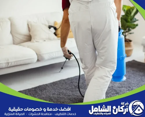 فني تنظيف يقوم برش مادة لإبادة الصراصير على سجادة للحفاظ على نظافتها. خدماتنا تشمل تنظيف شامل ومكافحة الحشرات. اتصل بشركة أركان الشامل على 0500073610.