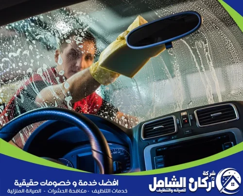 مسح وتنظيف الزجاج الأمامي من الداخل بعناية لضمان رؤية واضحة ونظيفة للسائق، كجزء من خدمة غسيل سيارات داخلي متنقل الشاملة.