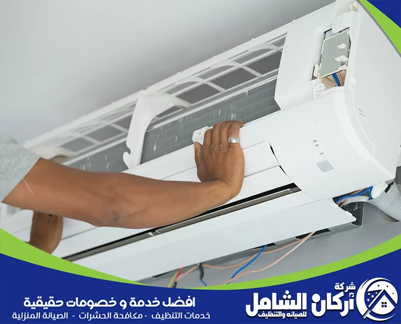 صيانة مكيفات سبليت بالخبر 0500073610 شركة أركان الشامل فني يفحص المكيف الجداري ويفتح الغطاء الداخلي لمراجعة الفلاتر والتوصيلات.