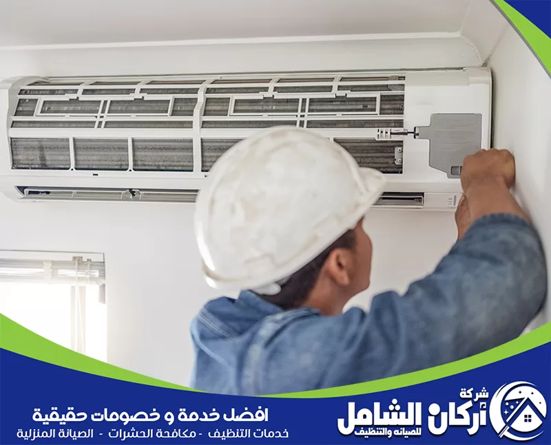 تمديد نحاس مكيفات بالدمام 0500073610 شركة أركان الشامل صورة لفني يقوم بتركيب مكيف سبليت، مع التركيز على المعدات المستخدمة.