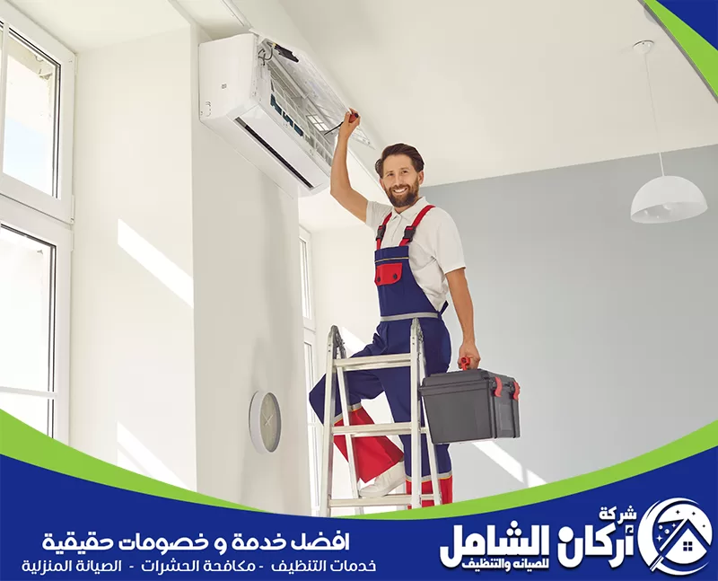 فك وتركيب ونقل مكيفات بالظهران 0500073610 أركان الشامل فني صيانة يفحص مكيف سبليت داخلي داخل منزل حديث، مع أدوات العمل اللازمة لتنظيف المكيف ومتابعة كفاءة التشغيل.